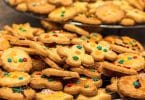 Imagem de duas travessas cheias de cookies todos decorados com açucar de confeiteiro.