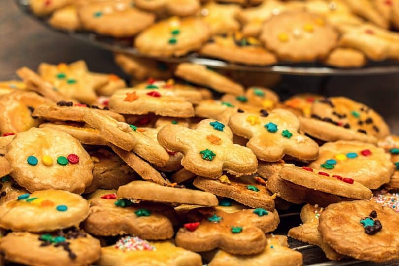 Imagem de duas travessas cheias de cookies todos decorados com açucar de confeiteiro.