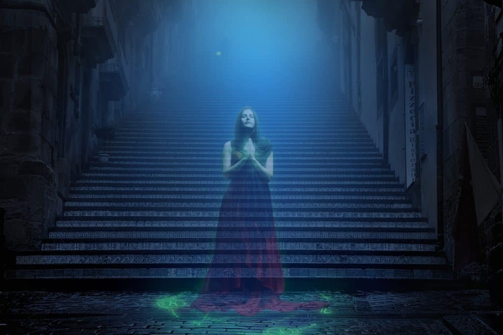 Imagem de uma assombração mulher parada no começo de uma grande e extensa escadaria. Ao fundo dela um forte luz na cor azul.