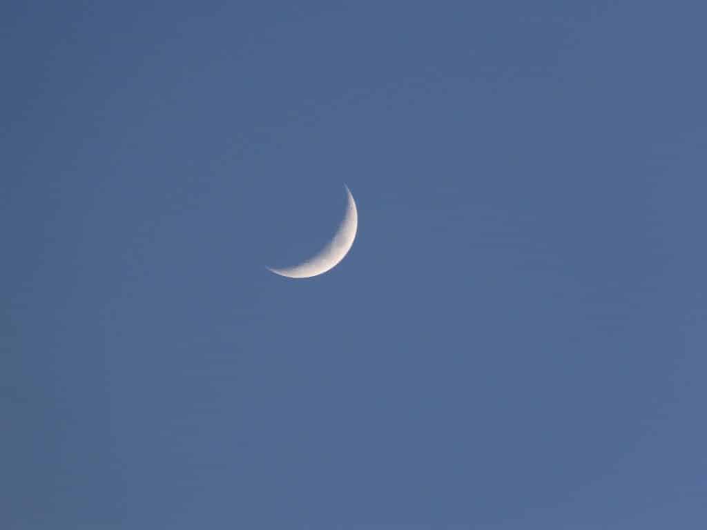 Imagem de cor azul e ao fundo a lua nova na cor branca.