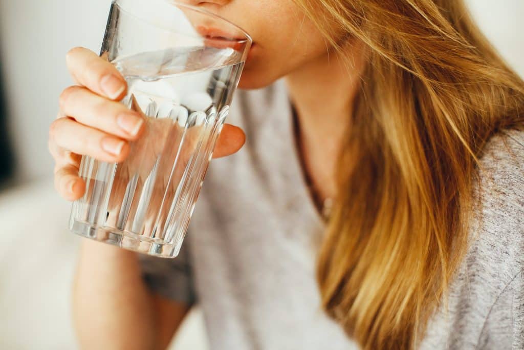 Mulher bebendo água no copo