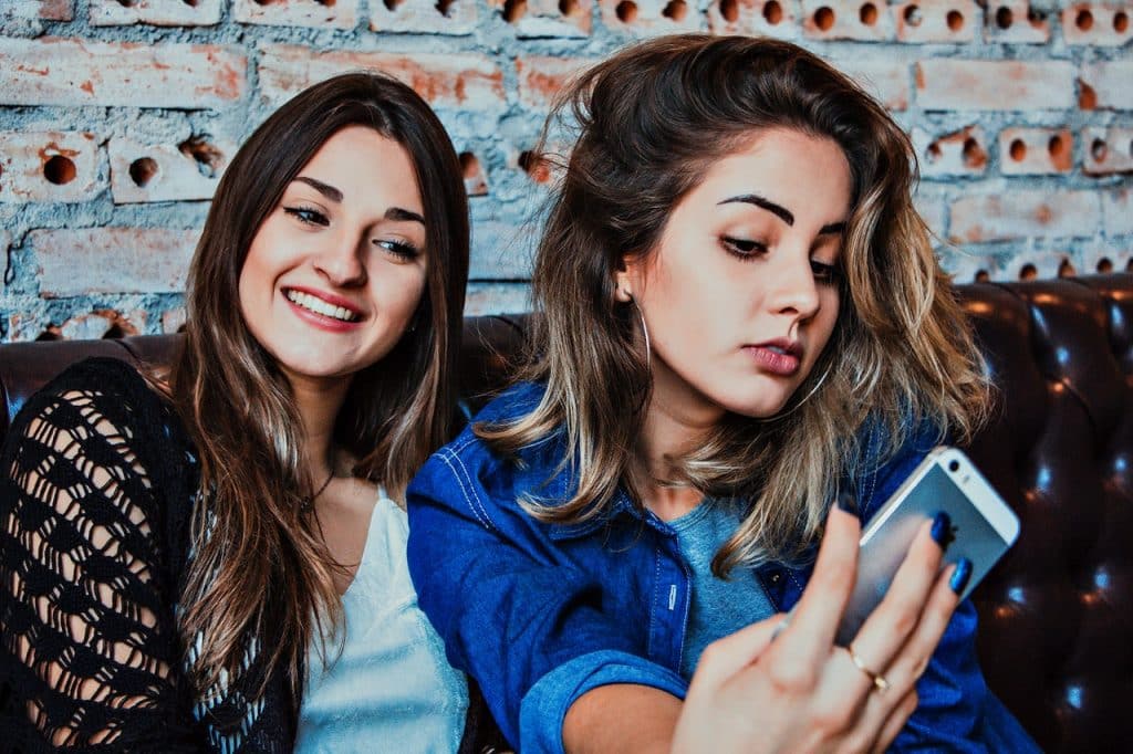 Duas mulheres, uma ao lado da outra, posam para uma foto.