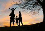 Silhueta de uma família observando o por do sol