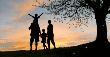 Silhueta de uma família observando o por do sol