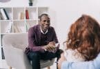 Terapeuta sorridente conversando com um jovem casal.