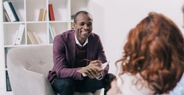 Terapeuta sorridente conversando com um jovem casal.