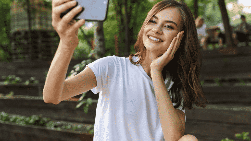 Mulher sorrindo enquanto tira selfie