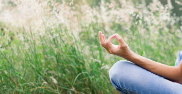 Pessoa meditando em um campo de flores