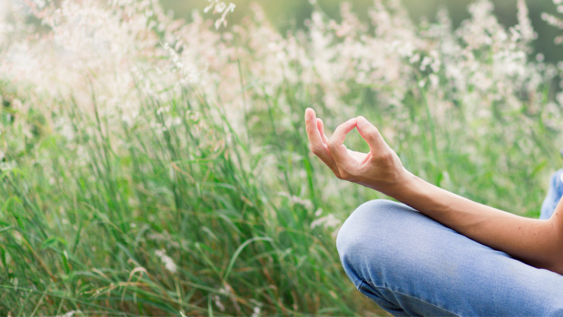 Pessoa meditando em um campo de flores