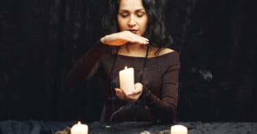 Mulher com velas acesas em cima da mesa