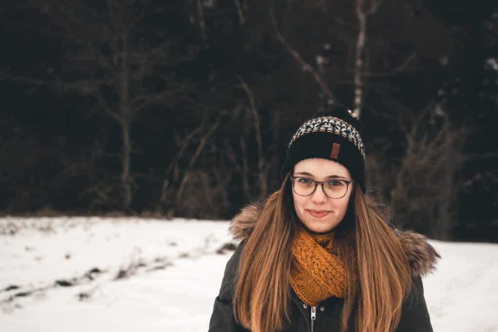 Mulher branca de roupas de frio na neve.