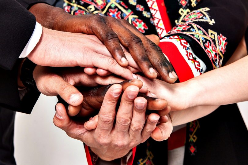 Imagem de várias mãos, de várias etnias e idades, mostrando a empatia e a generosidade em ajudar o próximo.