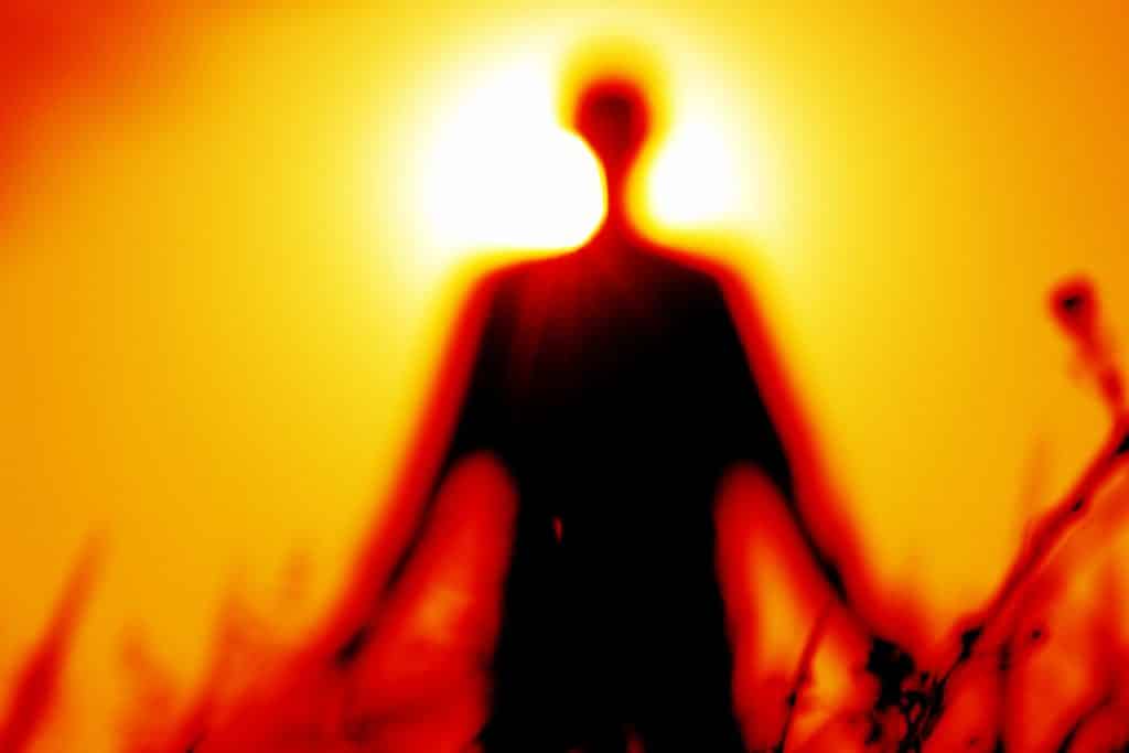 Imagem de fundo avermelhada, representando a energia solar e em destaque a silhueta de uma pessoa, representando a espiritualidade.