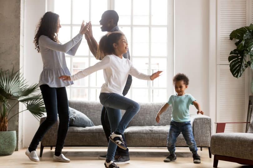 Família unida se relaciona em sala de estar.