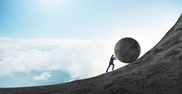 Homem empurrando uma grande pedra para o topo de montanha.