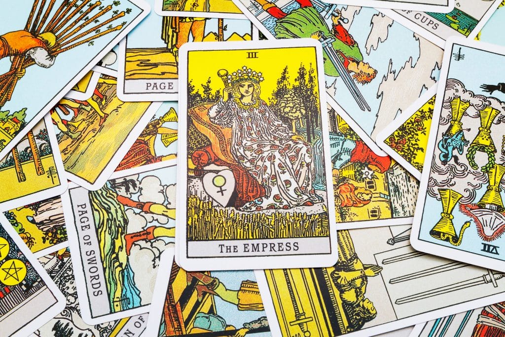 Carta "A Imperatriz" destacada dentre outras cartas de tarot.