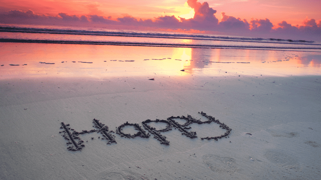 Imagem da palavra "Happy" (que significa "feliz" em inglês) escrita na areia da praia