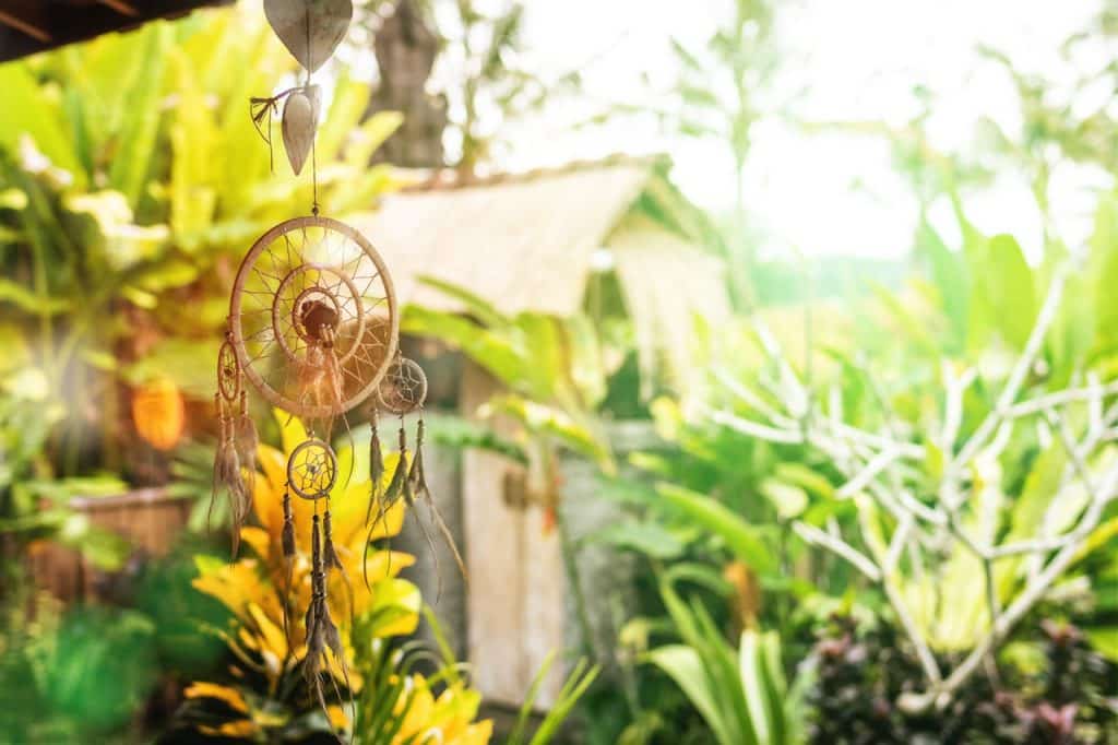 Filtro dos sonhos recebendo luz com plano de fundo repleto de folhagens