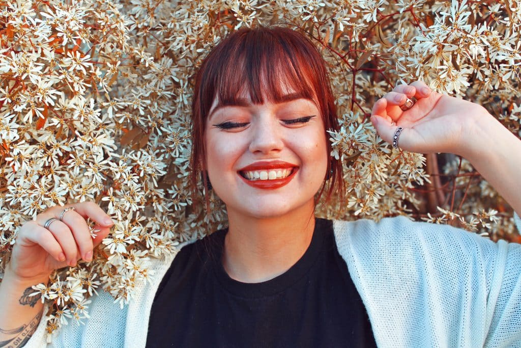 Mulher sorrindo deitada em flores