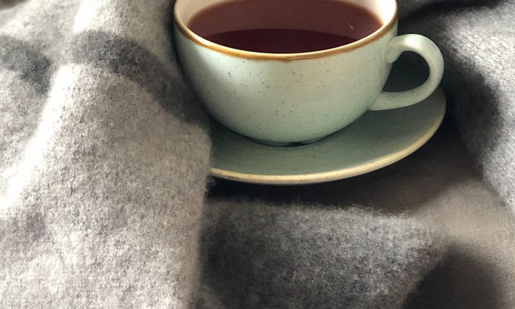 Xícara de chá envolta em cobertores.