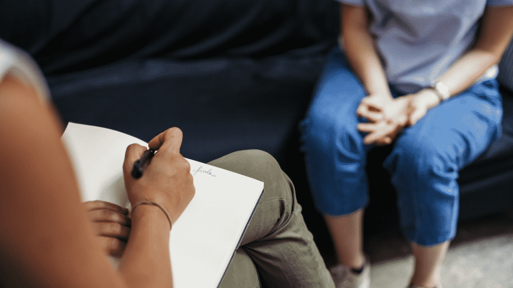 Psicóloga anotando em caderno durante a sessão