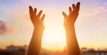 Mãos erguidas em direção ao sol.
