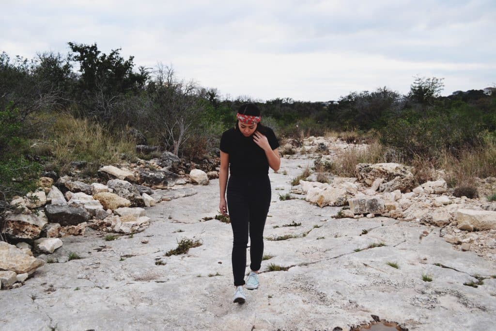 Mulher branca num campo desértico.