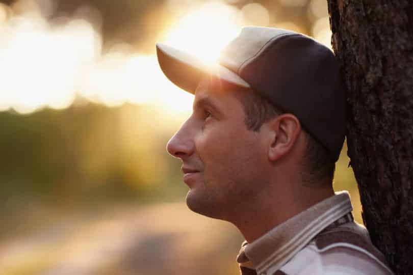 Perfil de homem branco usando boné.