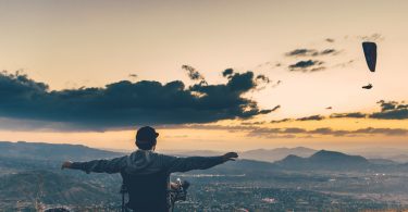 Homem sentado numa cadeira no topo de um morro.