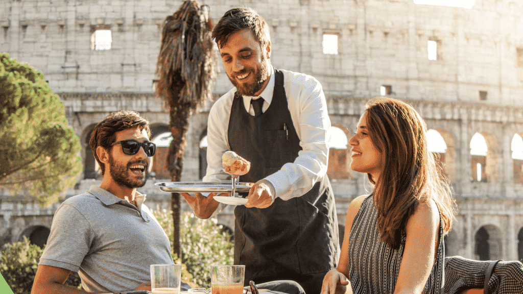 Garçom servindo uma sobremesa para um casal