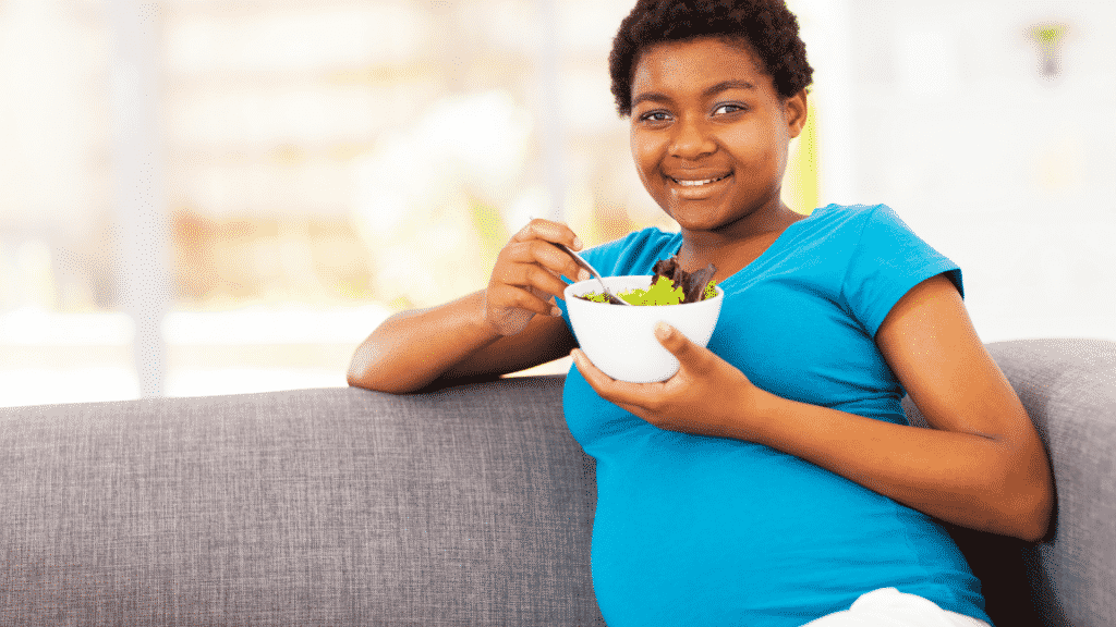 Mulher grávida comendo salada