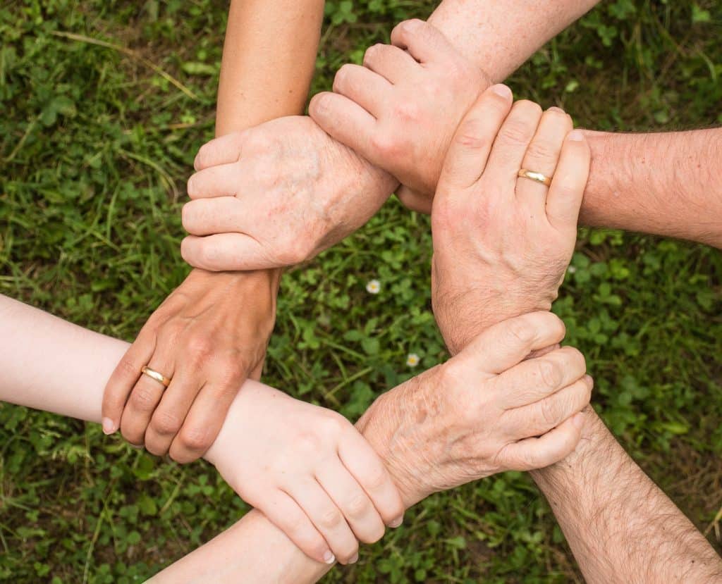 5 pessoas dando as mãos