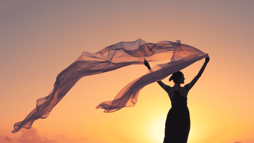 Silhueta de mulher segurando um lenço voando