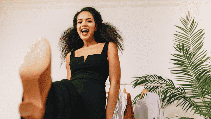 Mulher sorrindo com a perna erguida para a câmera