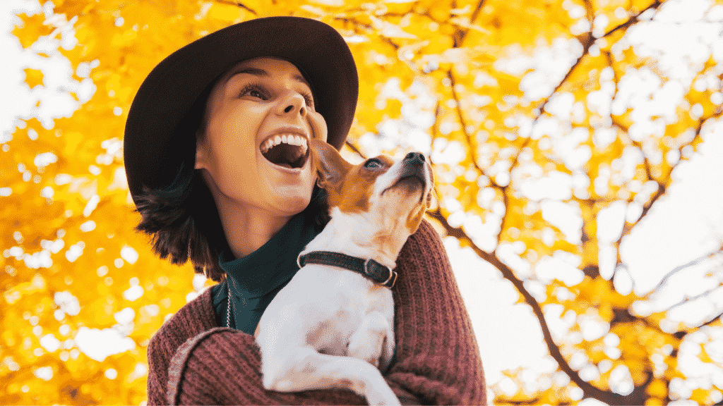 Mulher sorridente com o seu cachorro no colo