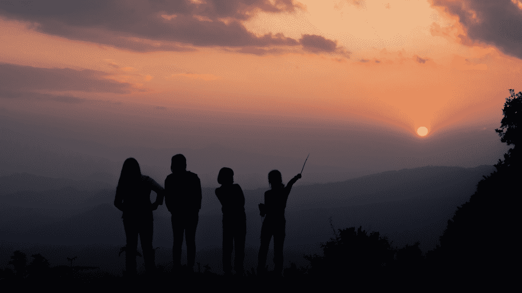 Silhueta de família observando o céu noturno