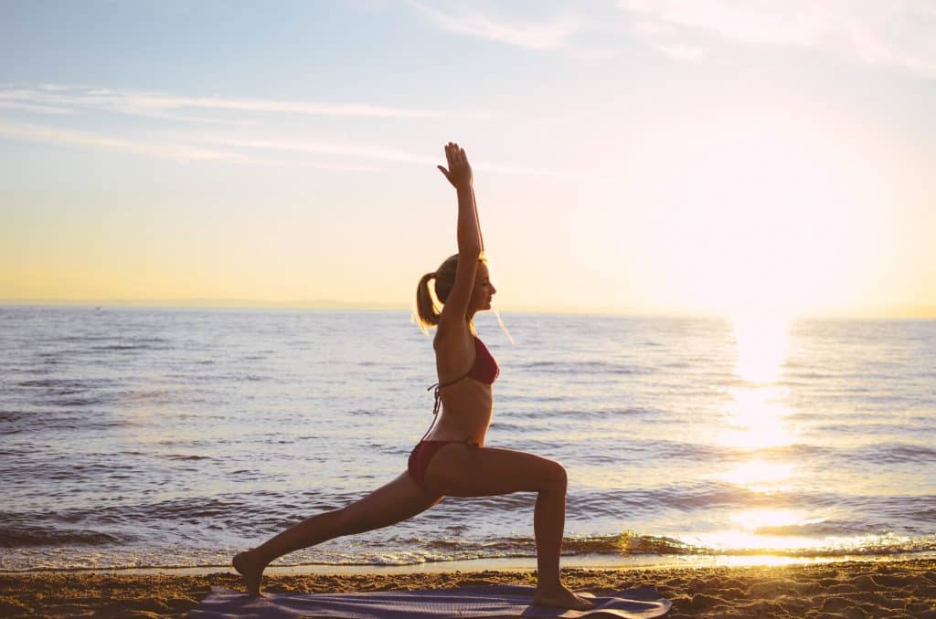 Mulher meditando na praia.