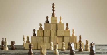 Peças de xadrez em cima de blocos de madeira.