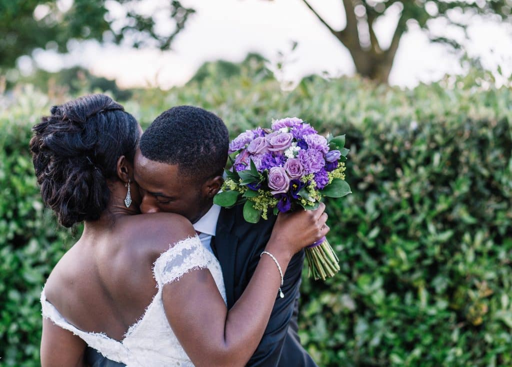 Homem e mulher negros abraçados no casamento.