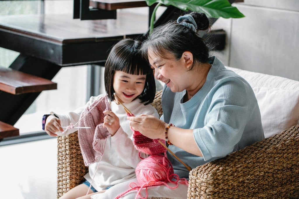 Mãe e filha juntas fazendo tricô