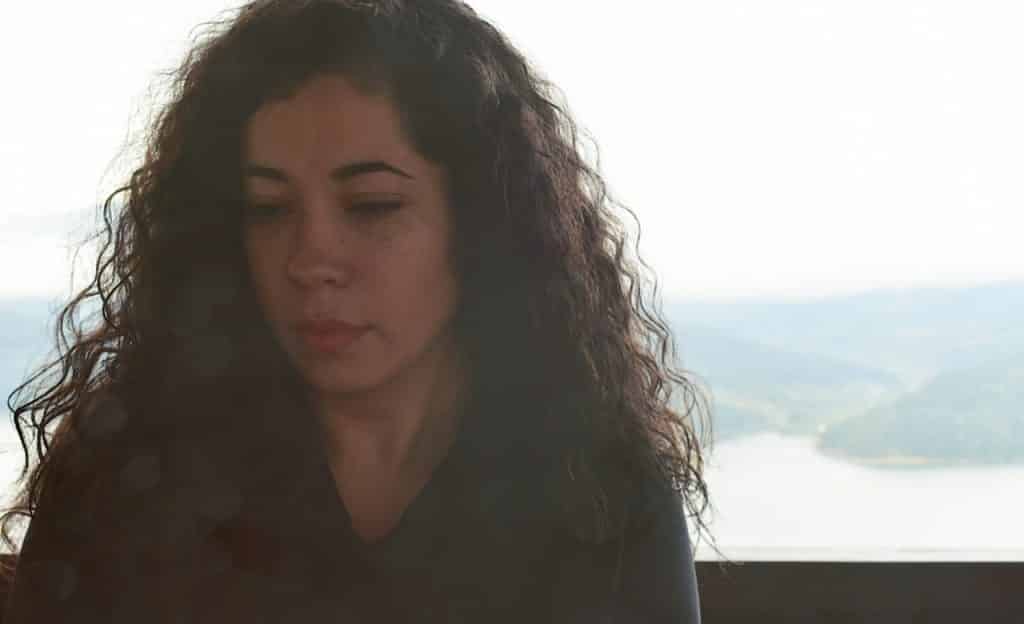 Mulher cabisbaixa com o semblante triste.