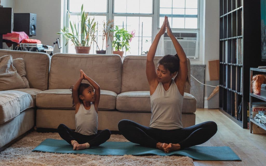 Mãe e filha fazendo yoga