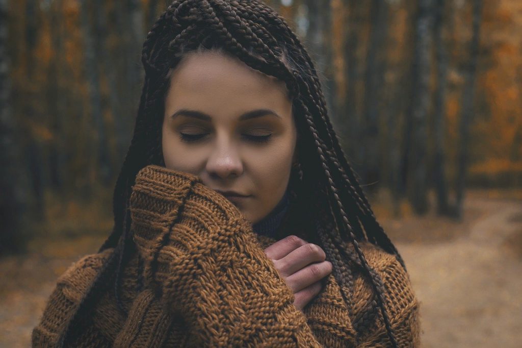 Mulher em uma floresta se sentindo conectada com a natureza