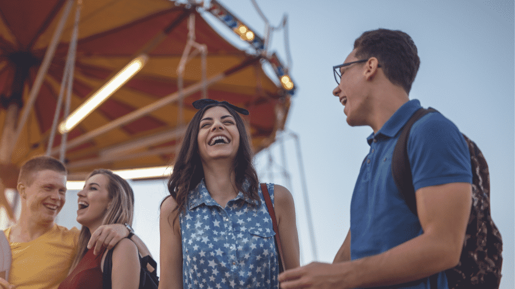 Jovens no parque de diversão rindo