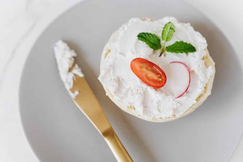 Queijo branco com tomate e folha em cima.