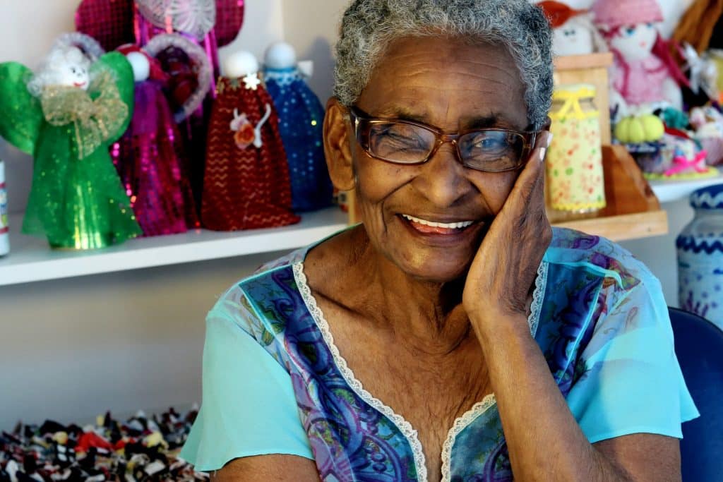 Idosa negra com expressão sorridente.