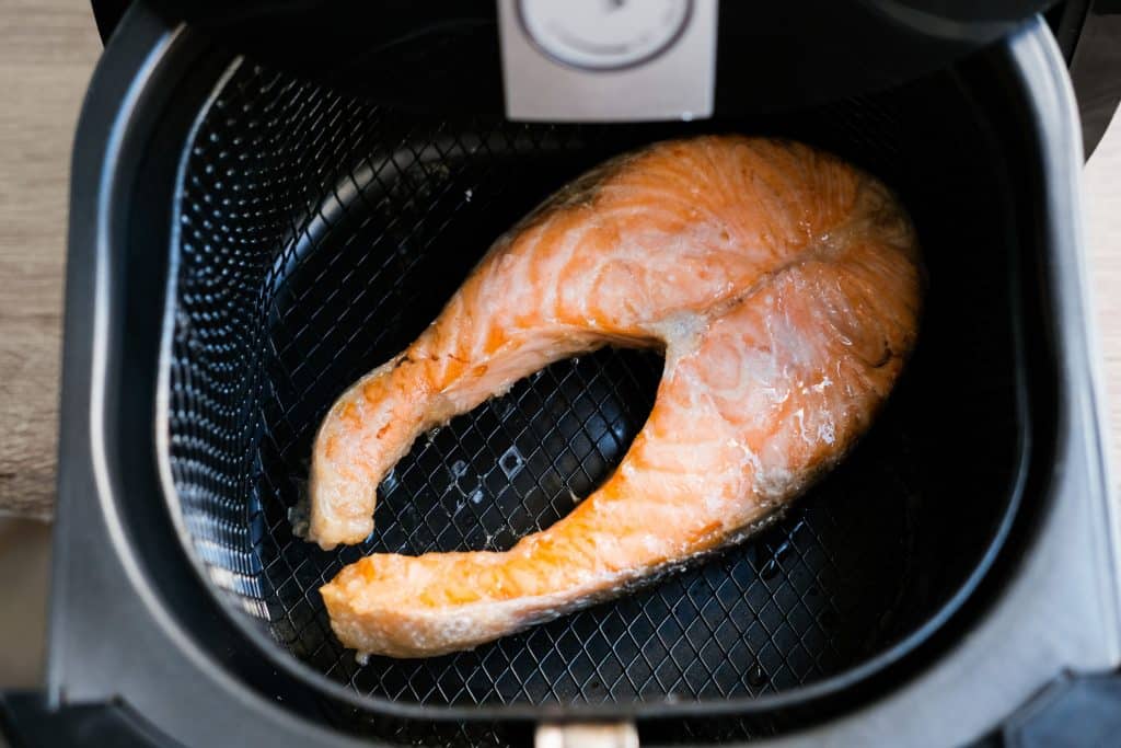 Salmão sendo grelhado em uma fritadeira elétrica.