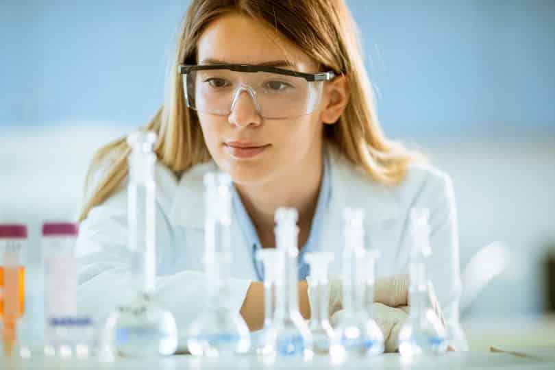 Mulher cientista observando tubos de ensaio