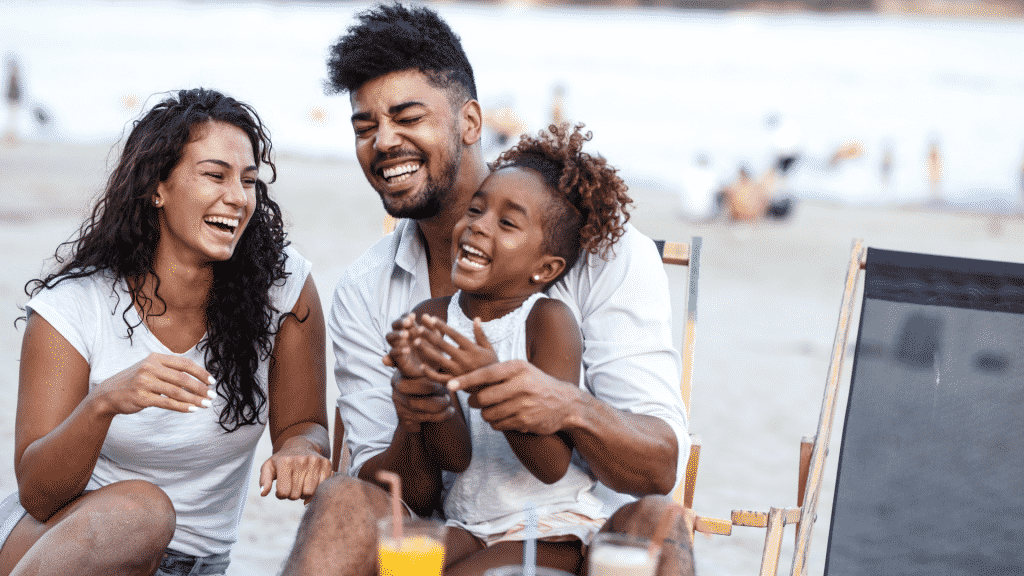 Familia junta e sorrindo na praia