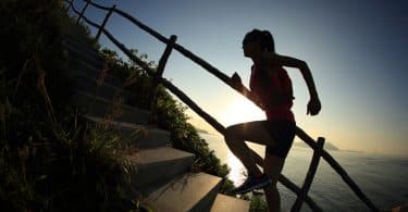 Mulher sobe por escadas em ambiente externo.